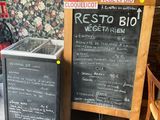 des tables et des chaises dans un restaurant où le menu est inscrit sur un tableau noir
