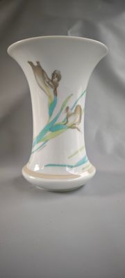 un vase blanc orné d'une image représentant une femme et un oiseau