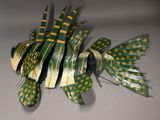 a green and yellow fish made out of strips of paper
