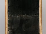 un vieux chevalet en bois surmonté d'un tableau noir