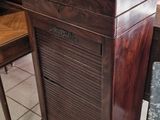 une petite armoire en bois posée à même le sol dans une pièce