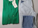 deux paires de jeans et un pull posés sur une table