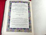 un livre ouvert posé sur une table recouverte d'une nappe rouge