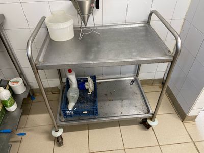 un petit chariot en métal sur lequel est posée une bouteille d'eau