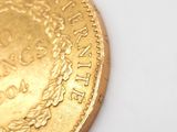 a close up of a gold coin on a white surface