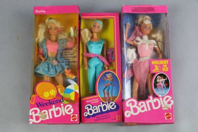 three barbie dolls are in their boxes on a white surface
