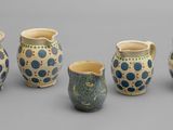 Plusieurs types de vases sont alignés sur une surface grise