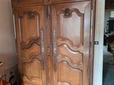 une grande armoire en bois dans le coin d'une pièce