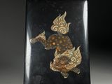 a black and gold plate with a fish design on it