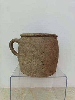 a large brown pot sitting on top of a clear shelf
