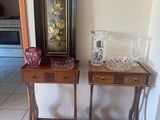 two small tables with vases on them in a room