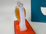 a bottle of perfume sitting on a table next to a box