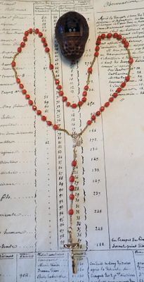 un chapelet et une croix posés sur un vieux livre