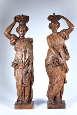 paire de statues anciennes en bois représentant des femmes portant des paniers