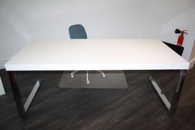 un bureau blanc avec une chaise bleue dans un coin