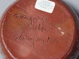 a brown vase with writing on it sitting on a table