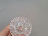 a person holding a clear glass object in their hand