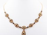 a gold and black necklace on a mannequin neck