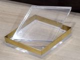 a clear box with a gold edge on a wooden table