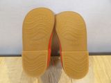 the soles of a pair of baby shoes on a wooden floor