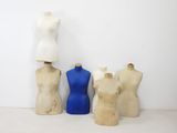 trois mannequins sont alignés contre un mur blanc