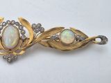 an oplite and diamond broochle is displayed on a white surface