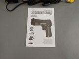a gun that is sitting on a table next to a charger
