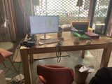 un bureau sur lequel se trouve un ordinateur, avec une chaise devant