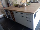 un îlot de cuisine avec un plan de travail en bois au milieu de la pièce