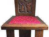 chaise en bois sur laquelle est posé un coussin rose