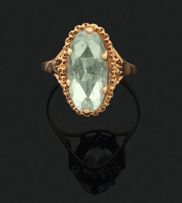 a gold ring with an oval aquamarinee stone surrounded by filigree filigree