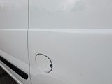 the side of a white van with a hole in the side of it