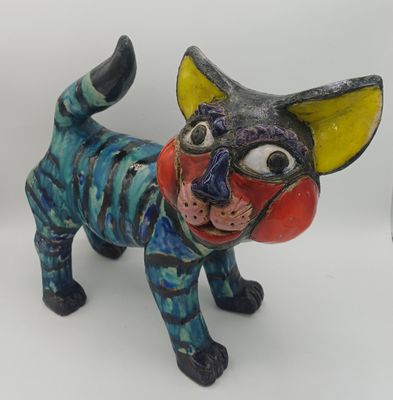 une figurine représentant un chat posée sur une surface blanche