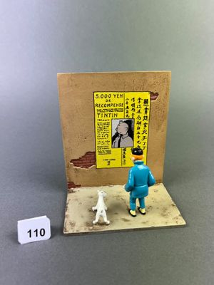 a small figurine of a man and a dog in front of a poster
