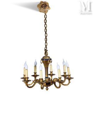 a brass chandelier with five candles hanging from the ceiling