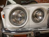 a close up of a car ' s headlight and the front end of the car