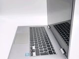 a silver laptop with a black keyboard on a white surface