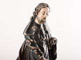 figurine of a man with a beard and a robe holding a bag