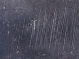 a close up of a metal surface with a lot of scratches on it
