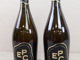deux bouteilles de vin posées sur une table l'une à côté de l'autre
