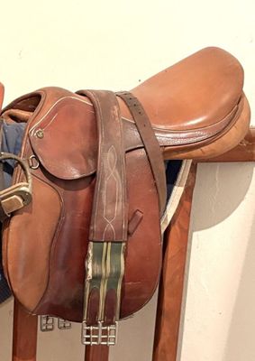 une selle de cheval et une selle posée sur un support en bois
