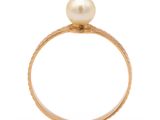 a close up of a gold ring with a pearl on top