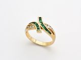 a gold ring with emerald stones and diamonds