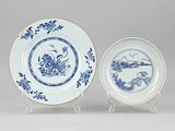 two blue and white plates with designs of birds and flowers