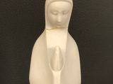 a white figurine of a woman holding a baby in her arms