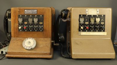 two old telephones sitting next to each other on a table
