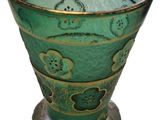 a green glass vase with a design on it