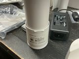 une tasse blanche posée sur une table, à côté d'autres objets