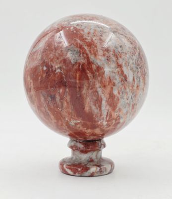 une photo d'une bille rouge posée sur un socle