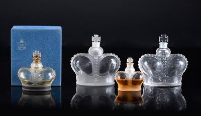 three bottles of perfume sitting on top of a table next to a box